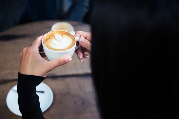 Mains féminines tenant tasse avec café — Photo