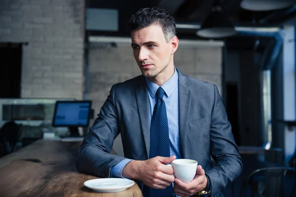 Uomo d'affari pensieroso che beve caffè nel caffè — Foto Stock