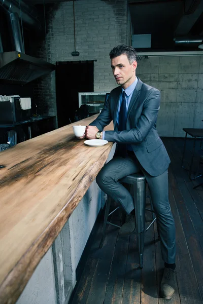 Selbstbewusster Geschäftsmann trinkt Kaffee im Café — Stockfoto