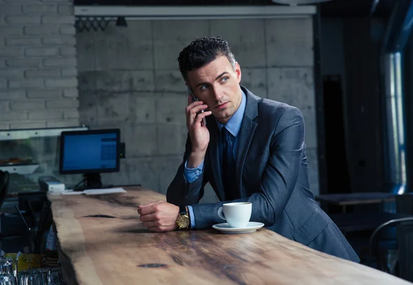 Fundersam affärsman prata i telefon i café — Stockfoto