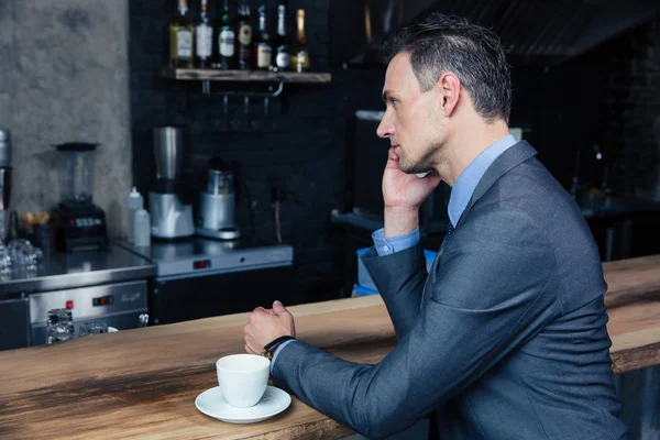 Pensativo hombre de negocios hablando por teléfono en la cafetería — Foto de Stock