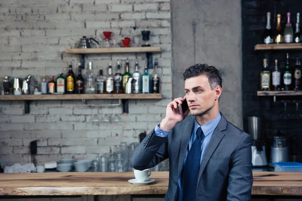 Homme d'affaires pensif parlant au téléphone dans un café — Photo