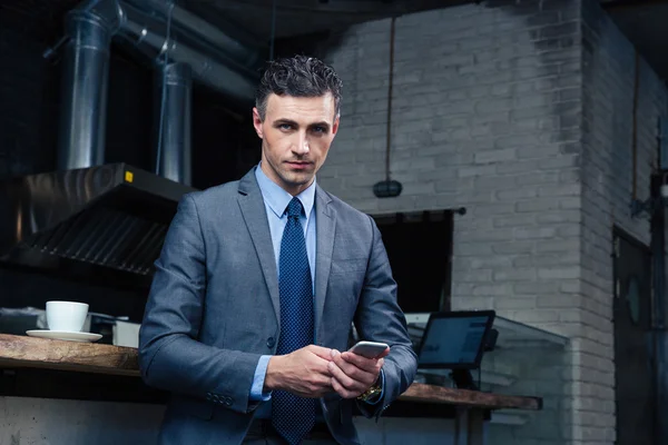 Businessman using smartphone in cafe — Stock Photo, Image