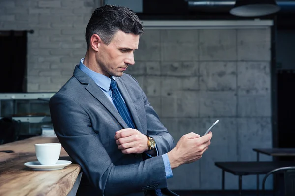 Uomo d'affari che utilizza smartphone in caffè — Foto Stock