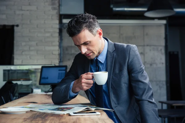 Businessman reading magazine in cafe — Stock Photo, Image