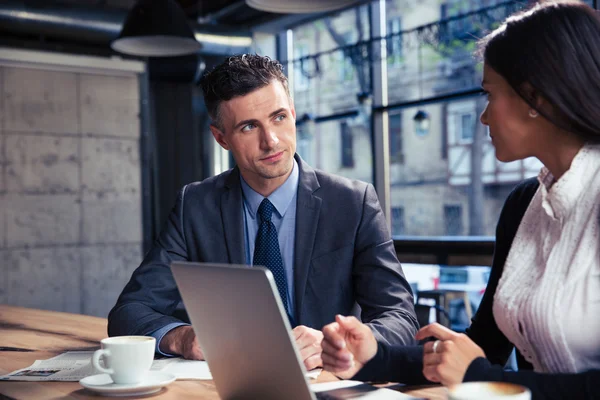 Empresario y mujer de negocios utilizando el ordenador portátil en la cafetería — Foto de Stock