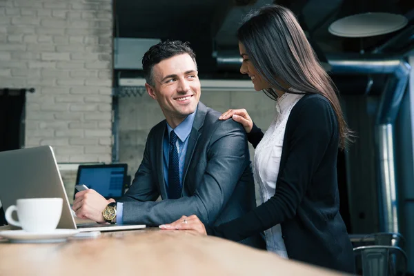 Empresario y mujer de negocios utilizando el ordenador portátil en la cafetería — Foto de Stock