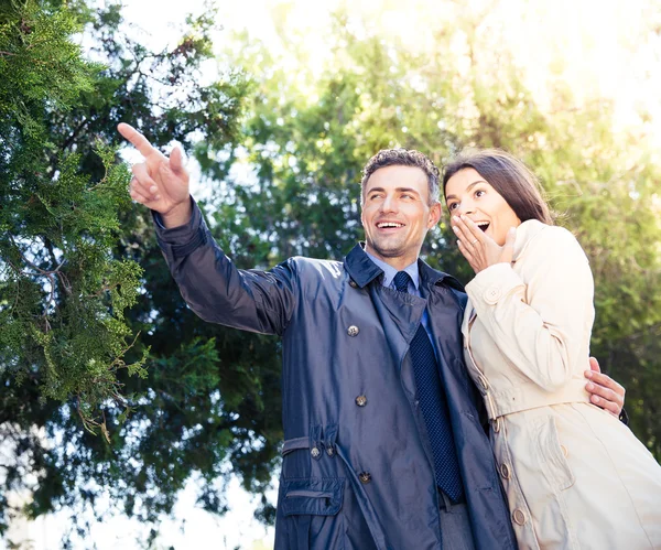 Uomo che punta su qualcosa con donna felice — Foto Stock