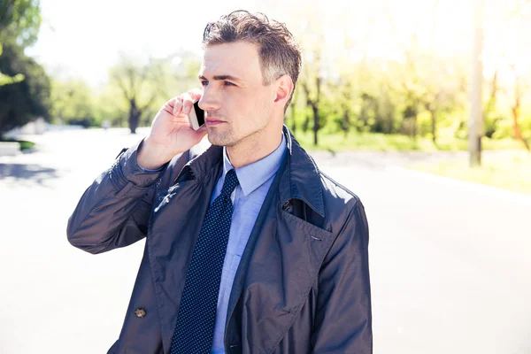 Confident businessman talking on the phone outdoors — Stock Photo, Image