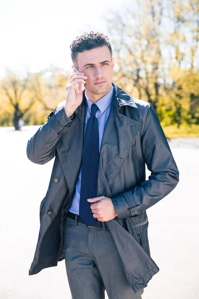 Hombre de negocios guapo hablando por teléfono al aire libre — Foto de Stock