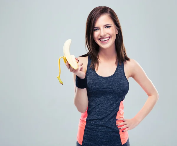 Sorridente donna sportiva con banana — Foto Stock