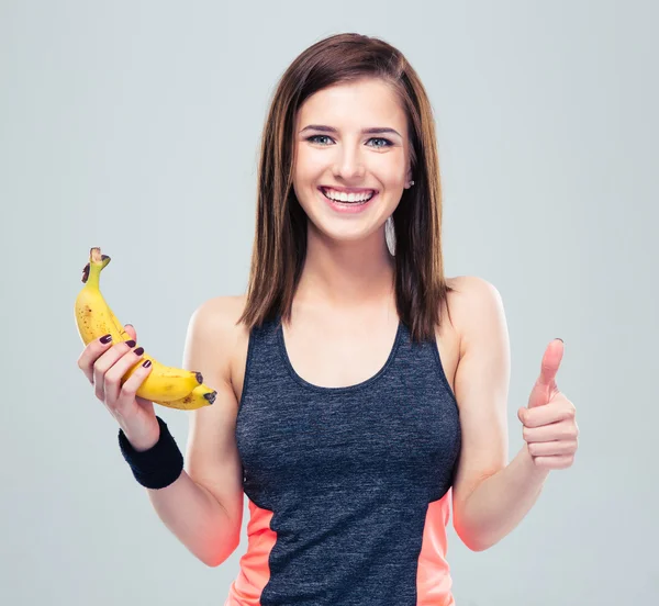 Woman holding banana and showing thumb up — Stock Photo, Image