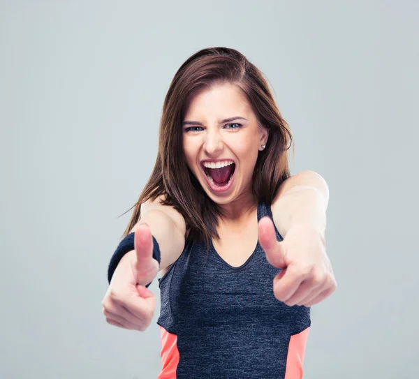 Sports woman showing thumbs up and screaming — Stock Photo, Image