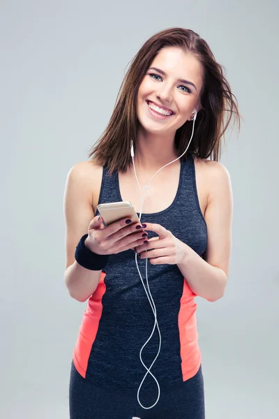Leende fitness kvinna med smartphone — Stockfoto