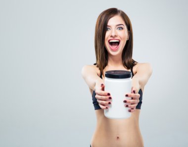 Kavanoz protein ile neşeli gülümseyen sportif kadın