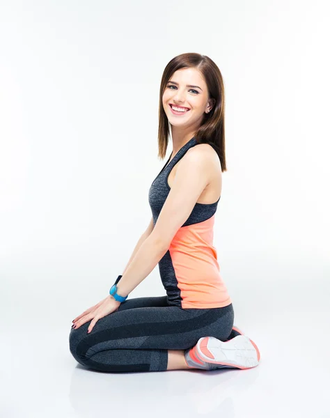 Mujer deportiva sonriente sentada en el suelo — Foto de Stock