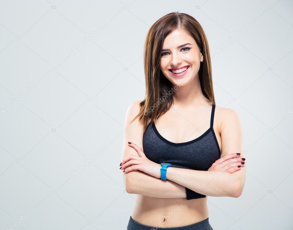 Cheerful young woman standing with arms folded 