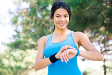 Gülümseyen sportif kadın akıllı izle açık havada kullanma