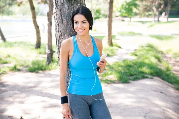 Happy bijaksana wanita berdiri dengan smartphone outdoors — Stok Foto