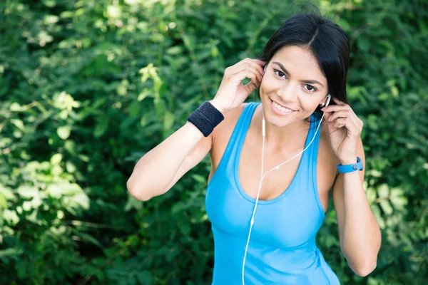Szczęśliwa kobieta sportowy w słuchawkach na zewnątrz — Zdjęcie stockowe