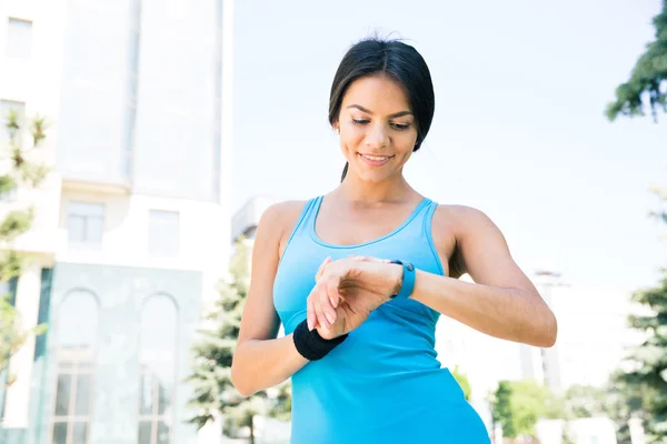 Glada sportiga kvinnan använder smart Watch-klocka — Stockfoto