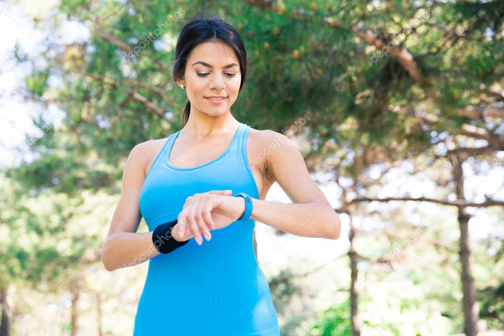 Happy sporty woman using smart watch