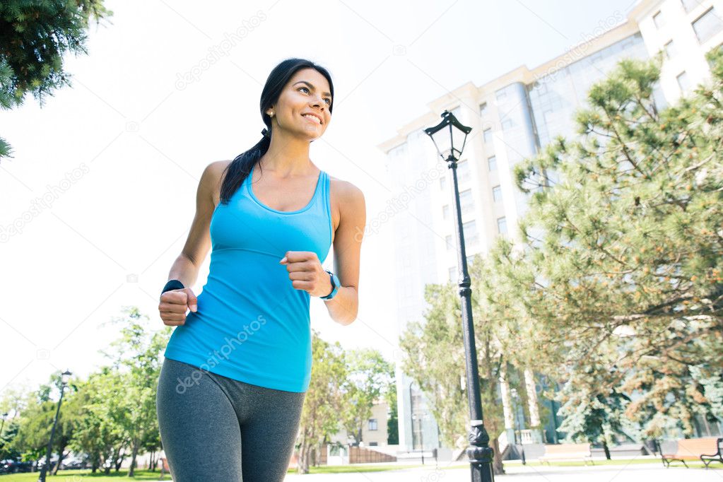 Happy young woman running outdoors