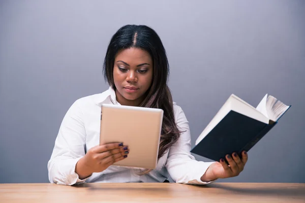 Businesswoman choosing between e-book or paper book — Stock Photo, Image