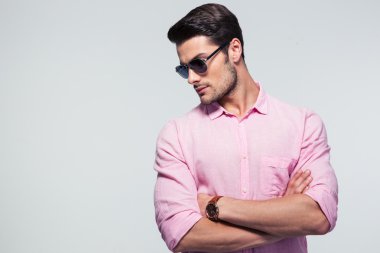 Moda gri arka plan üzerinde durup gözlüklü genç adam