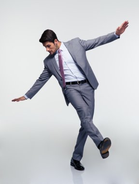 Gri arka plan üzerinde uçan iş adamı