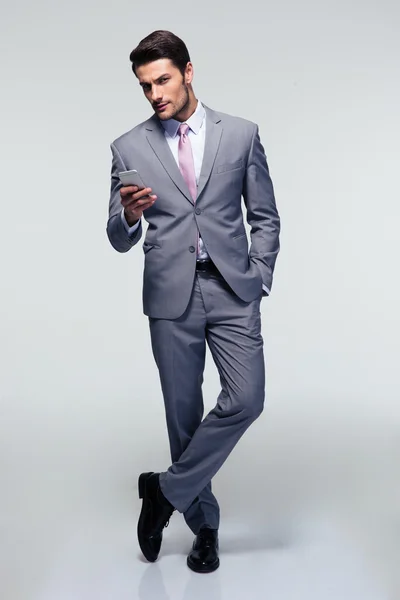 Pełnej długości piękny portret biznesmena z smartphone — Zdjęcie stockowe