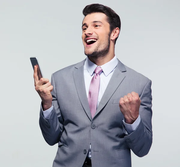 Веселий бізнесмен тримає смартфон — стокове фото