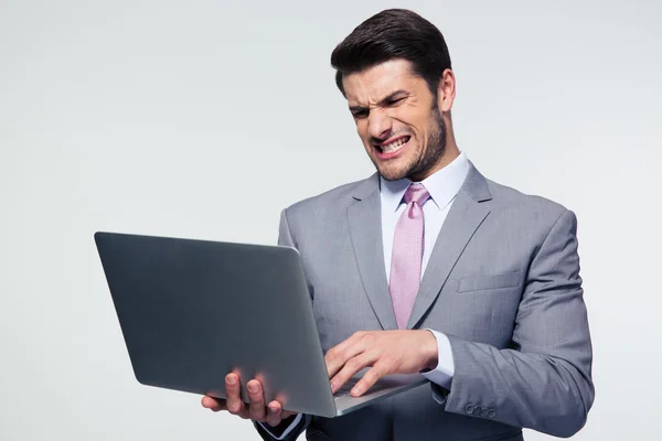 Злой бизнесмен, использующий ноутбук — стоковое фото