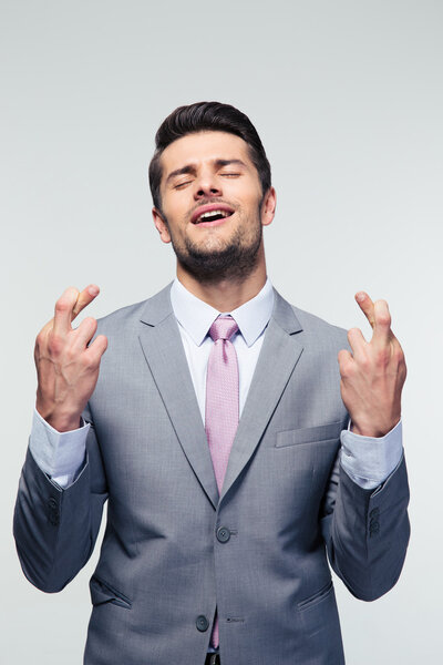 Businessman with fingers crossed