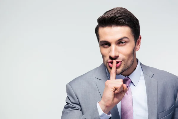 Businessman pointing finger over lips, asking for silence — Stock Photo, Image