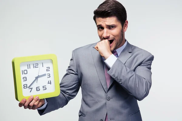 Hombre de negocios preocupado sosteniendo reloj —  Fotos de Stock