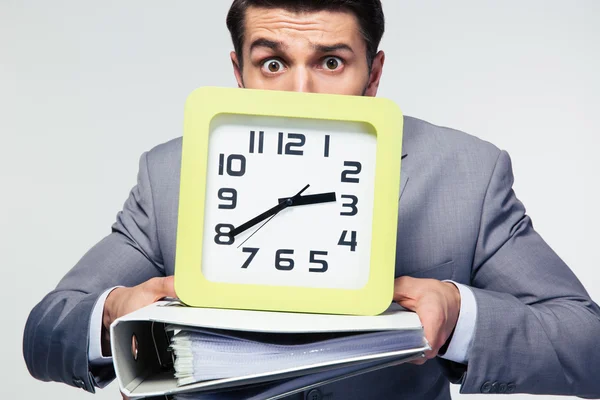 Businessman holding folders and clock — Stock Photo, Image