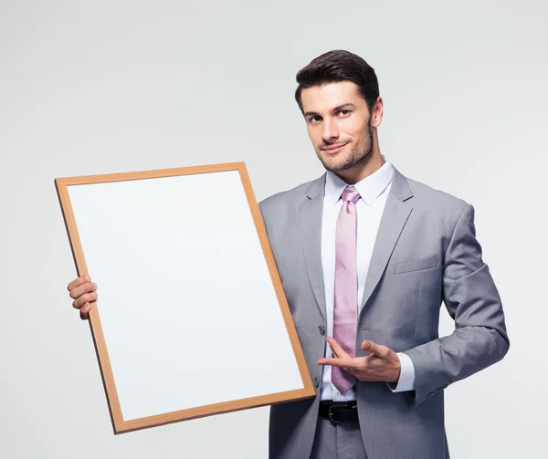 Gelukkig zakenman presenteren leeg bord — Stockfoto