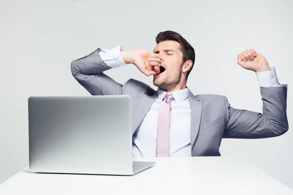 Empresário sentado à mesa e bocejando — Fotografia de Stock