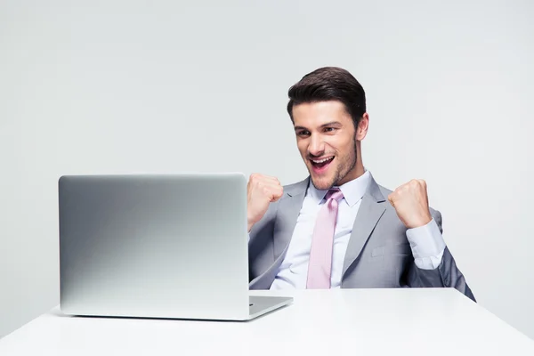 Framgångsrik glad affärsman tittar på laptop — Stockfoto