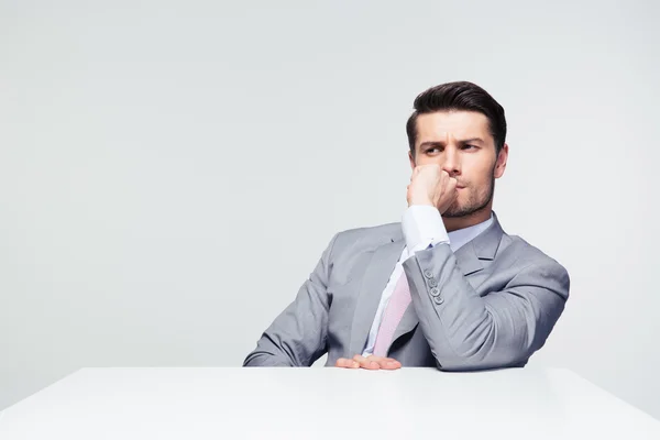 Nachdenklicher Geschäftsmann sitzt mit am Tisch — Stockfoto