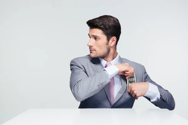 Empresario poniendo dinero en el bolsillo — Foto de Stock