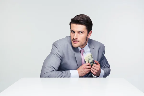 Empresario poniendo dinero en el bolsillo — Foto de Stock