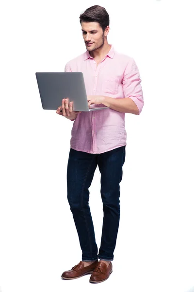 Młody człowiek stojący i korzysta z laptopa — Zdjęcie stockowe