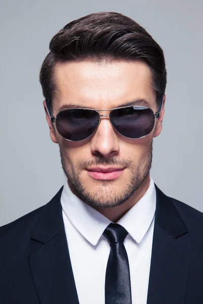Geschäftsmann mit Sonnenbrille blickt in Kamera — Stockfoto