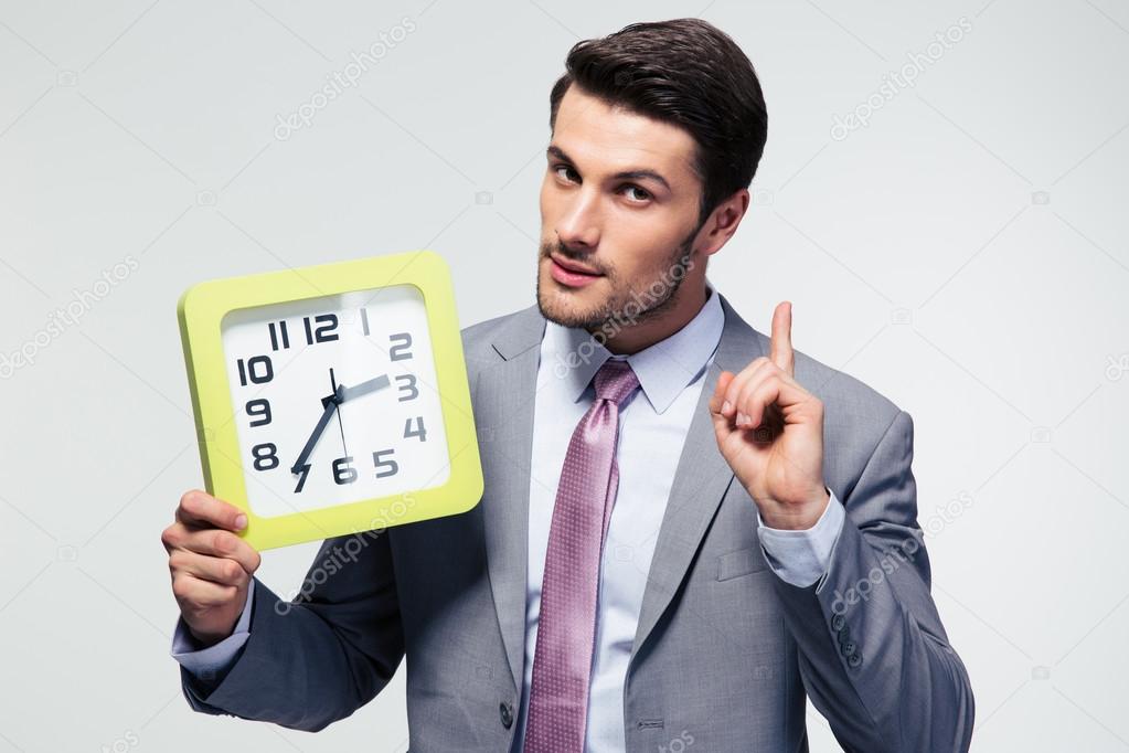 Businessman holding clock 
