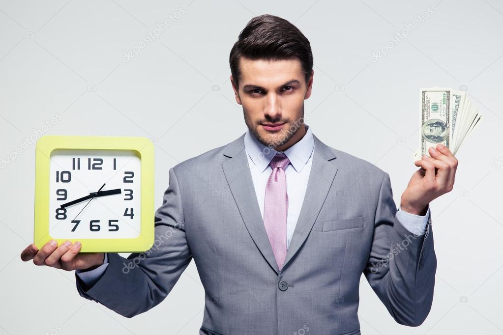 Businessman holding money and clock