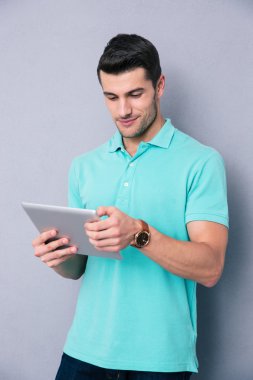 Tablet bilgisayar kullanan mutlu genç adam 