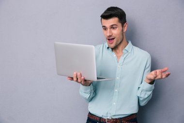 Dizüstü bilgisayar kullanan mutlu casual adam 