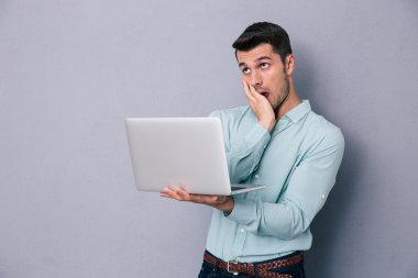 Laptop ile ayakta yorgun casual adam